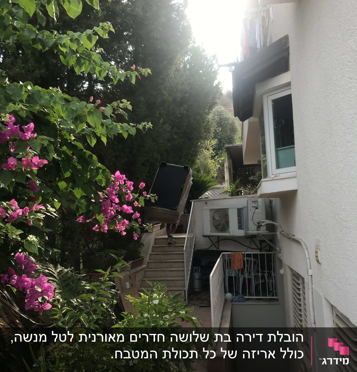 אדם נושא כיסא במעלה מדרגות ליד בית